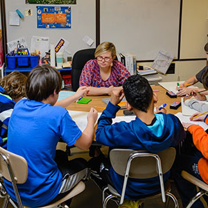 teacher with students at table